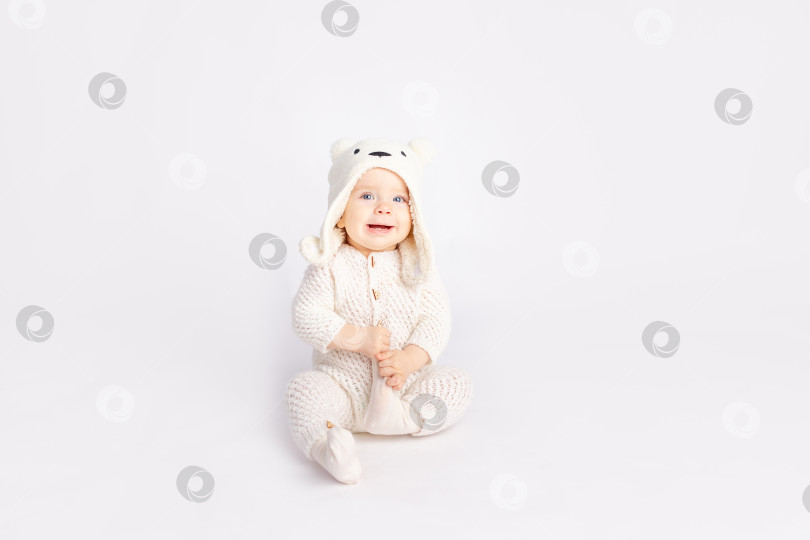 Скачать ребенок в теплом костюме и шапочке с медведем на белом изолированном фоне, место для текста фотосток Ozero