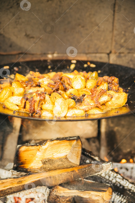 Скачать Летнее блюдо. Мясо с овощами, луком и картофелем, которое обжаривается в казане. Вид сверху. Кавказская или азиатская кухня. фотосток Ozero