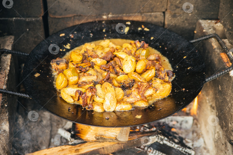 Скачать Летнее блюдо. Мясо с овощами, луком и картофелем, которое обжаривается в казане. Вид сверху. Кавказская или азиатская кухня. фотосток Ozero