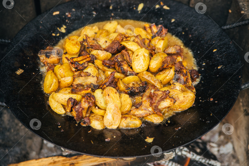 Скачать Крупный план летнего мяса с овощами, луком и картофелем, обжаренного в казане. Вид сверху. Кавказская или азиатская кухня. фотосток Ozero