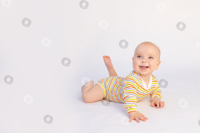 Скачать маленькая улыбающаяся девочка 6 месяцев лежит на белом изолированном фоне в ярком боди, место для текста. Здоровый счастливый ребенок. фотосток Ozero