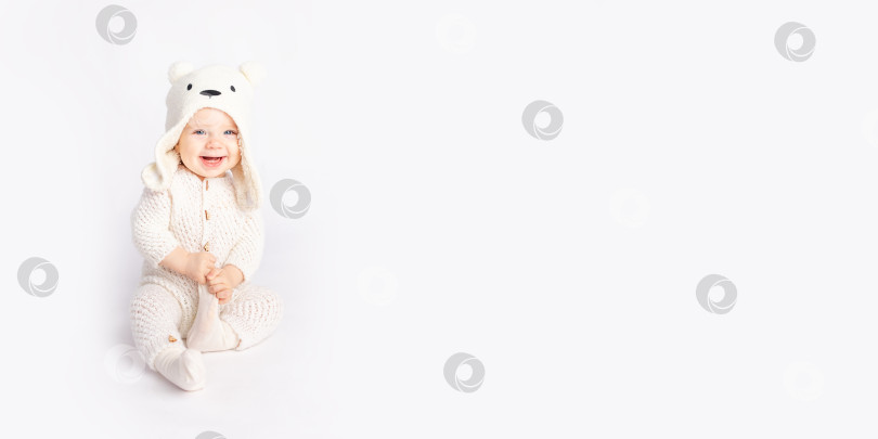 Скачать ребенок ползает в теплом костюме и шапочке на белом изолированном фоне, место для текста, баннер фотосток Ozero