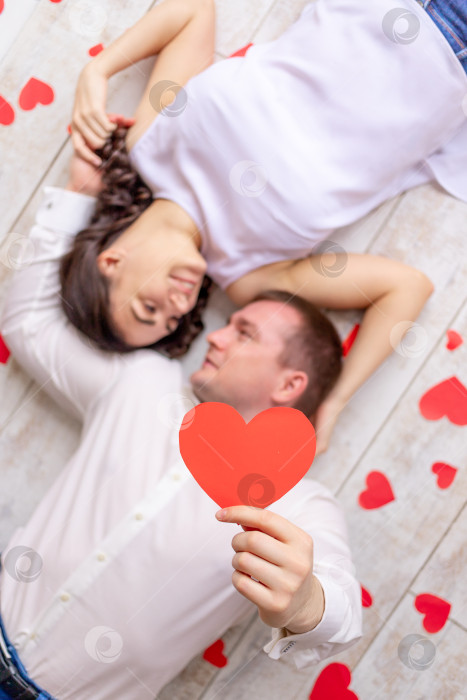 Скачать день святого Валентина, влюбленная пара лежит среди сердец на f фотосток Ozero