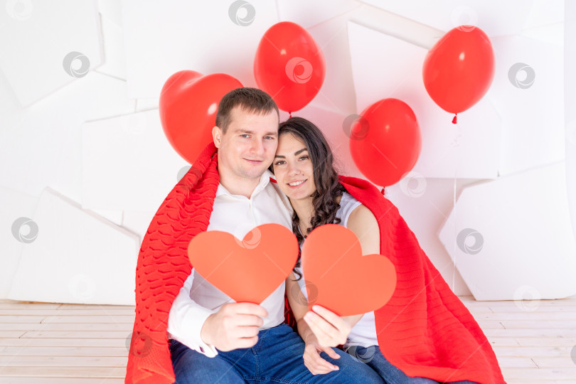 Скачать день святого Валентина, влюбленная пара держит в руках красные сердечки фотосток Ozero