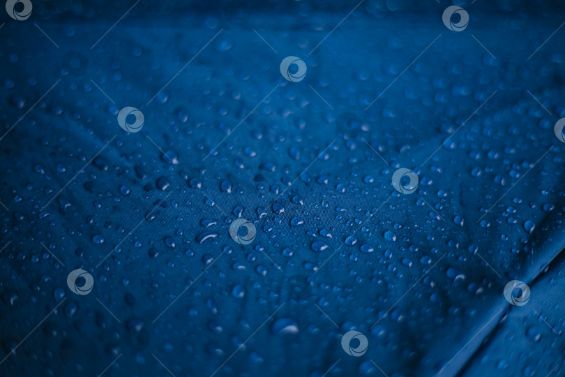 Скачать Капли дождевой воды на синем фоне из водонепроницаемой ткани. Текстура и абстрактный фон. фотосток Ozero