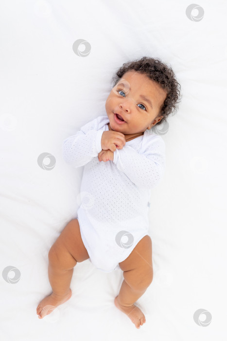 Скачать маленький ребенок-афроамериканец на белой кровати в спальне фотосток Ozero