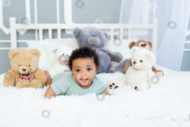 Скачать афроамериканский мальчик шести месяцев от роду на кровати среди плюшевых мишек фотосток Ozero