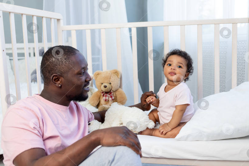 Скачать афроамериканская семья, папа и маленький сын разговаривают или играют дома в спальне, счастливый отец фотосток Ozero