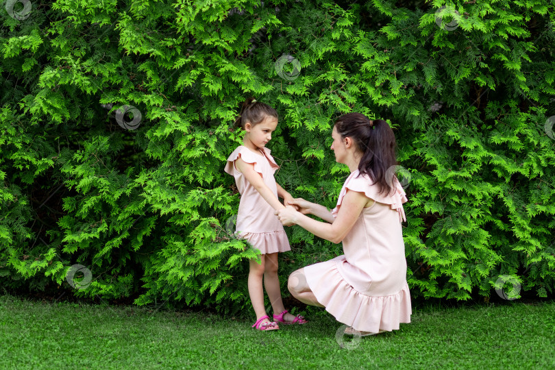 Скачать мать и дочь 5-6 лет гуляют летом в парке, дочь и мать смеются на скамейке, концепция счастливой семьи, отношения матери и ребенка, день матери фотосток Ozero