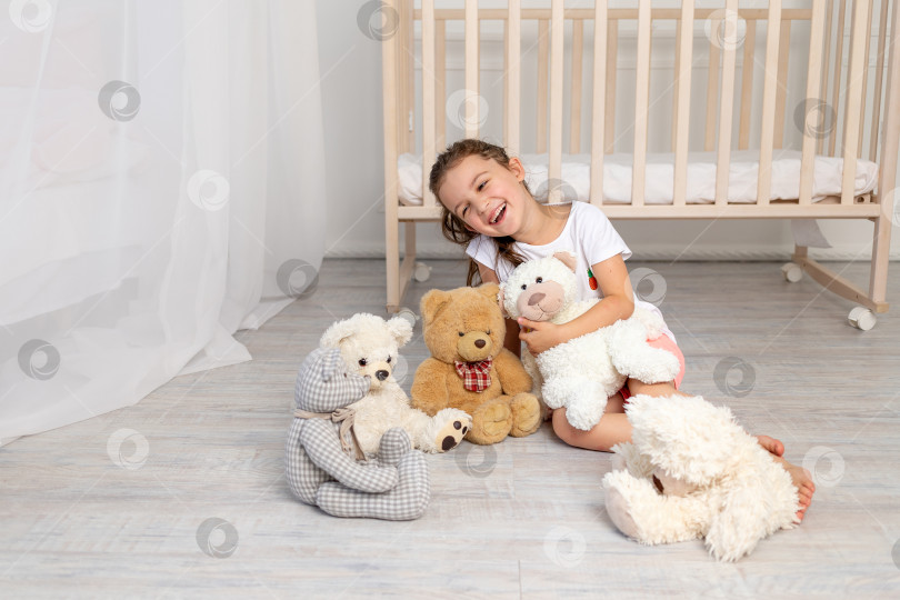 Скачать маленькая девочка 5-6 лет играет в детской комнате с плюшевыми мишками фотосток Ozero