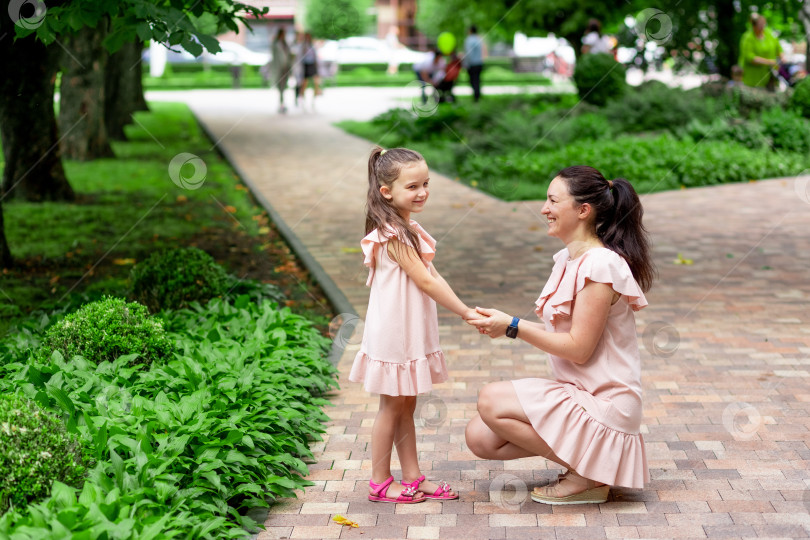 Скачать Счастливая мать и дочь 5-6 лет гуляют летом в парке, мать разговаривает с дочерью, понятие счастливой семьи, отношения матери и ребенка фотосток Ozero