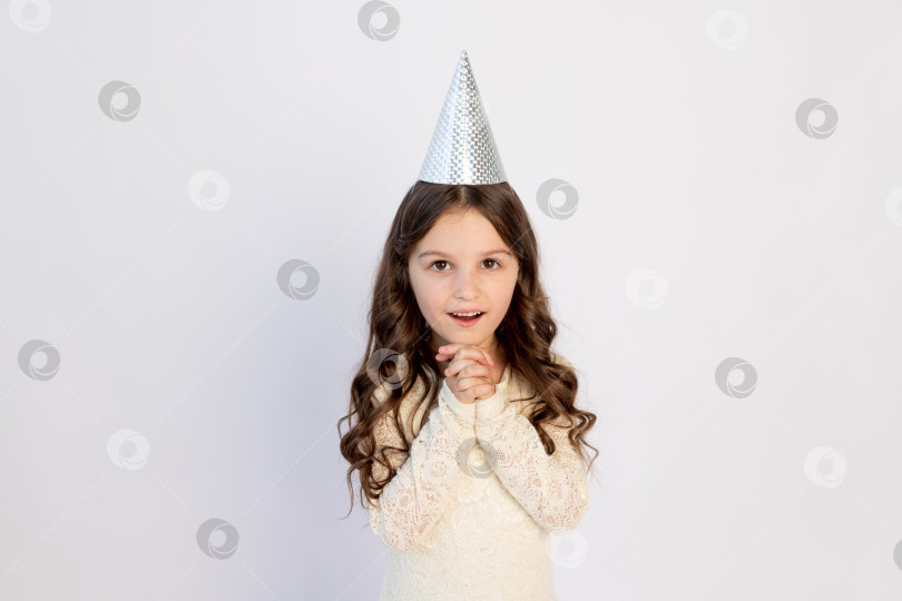 Скачать Молодая девушка в свой день рождения в образе принцессы в шляпке загадывает желание на изолированном белом фоне, молодая красивая девушка хочет получить подарок фотосток Ozero