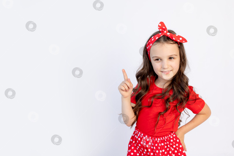Скачать Симпатичная маленькая девочка в красном наряде на белом изолированном фоне показывает большой палец вверх. Пространство для текста. концепция празднования и распродажи фотосток Ozero