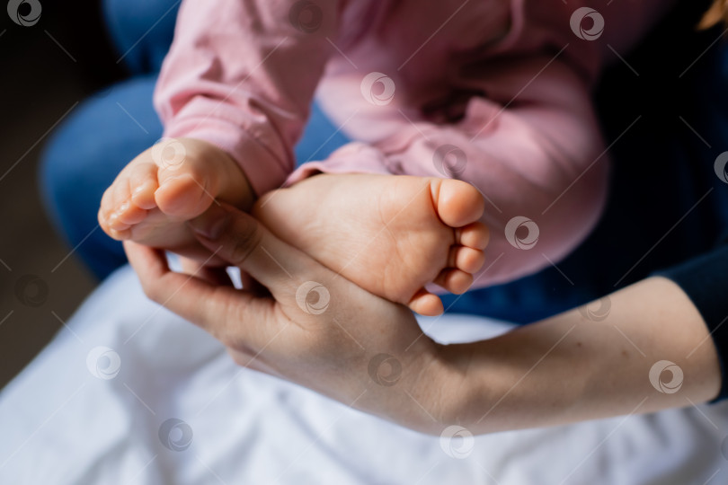 Скачать Ножки ребенка в руках мамы крупным планом фотосток Ozero