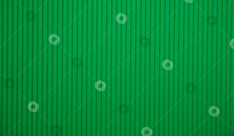 Скачать Абстрактный фон из гофрированной бумаги для нанесения в зеленом цвете. Пространство для текста. Текстура. Вертикальные полосы. фотосток Ozero