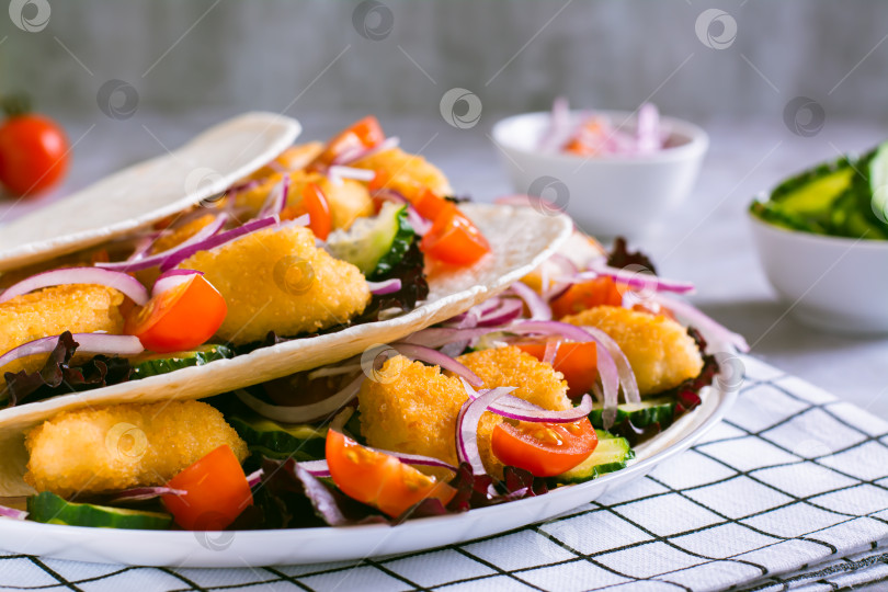 Скачать Тортилья с куриными наггетсами, овощами, луком и листьями салата на фотосток Ozero