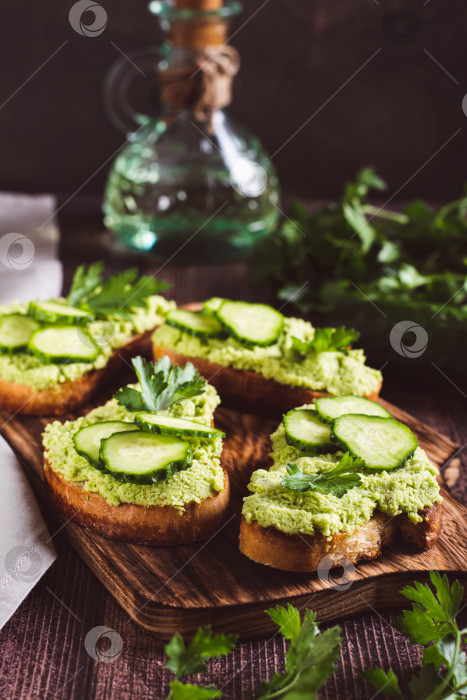 Скачать Аппетитные тосты с гуакамоле, огурцами и зеленью на гриле фотосток Ozero