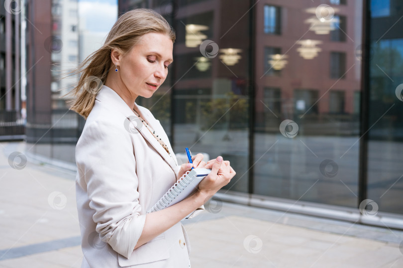 Скачать Деловая женщина пишет ручкой в блокноте. Кавказская успешная девушка в свете фотосток Ozero