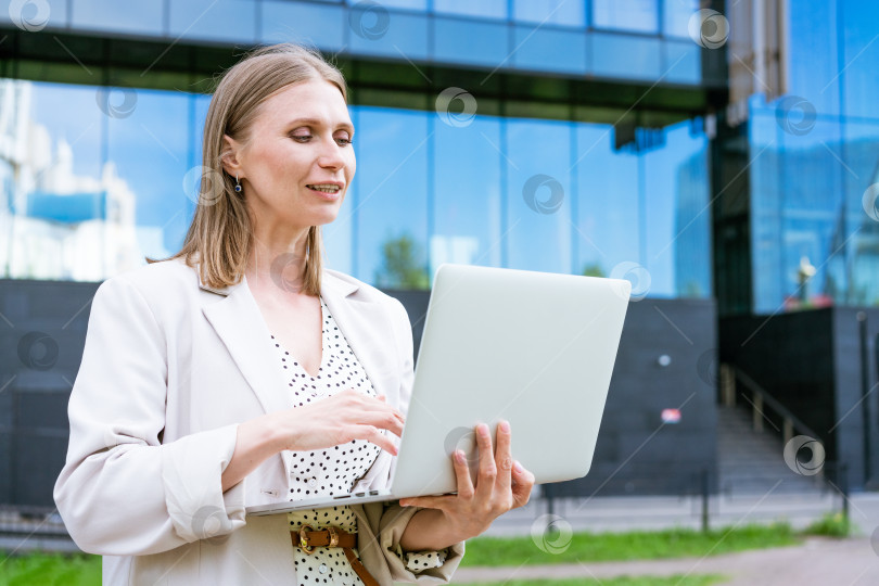 Скачать Деловая женщина добивается успеха в бизнесе. Очаровательная красивая женщина держит в руках ноутбук фотосток Ozero