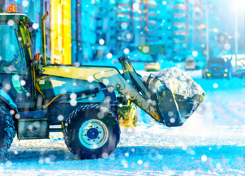 Скачать Снегоочиститель, трактор в выборочном фокусе убирают снег на проезжей части улицы в снежную бурю. фотосток Ozero