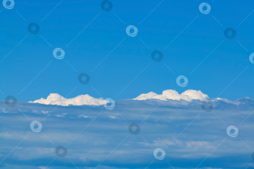 Скачать пейзаж из кучевых облаков на большой высоте. Вид на облака из иллюминатора самолета. фотосток Ozero