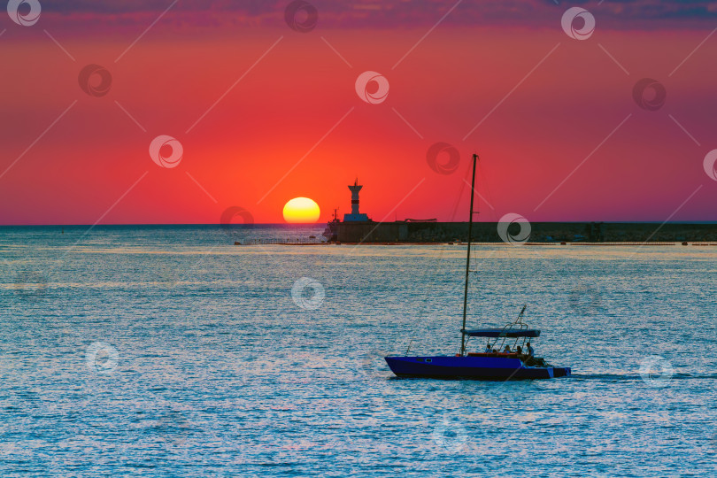 Скачать Силуэт лодки на закате на морском горизонте в Севастополе, Крым.Концепция вечерних морских прогулок, отдыха на море. фотосток Ozero
