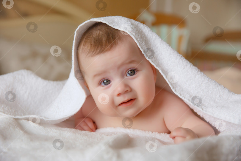 Скачать ребенок, накрытый полотенцем после купания, лежит на кровати в т фотосток Ozero
