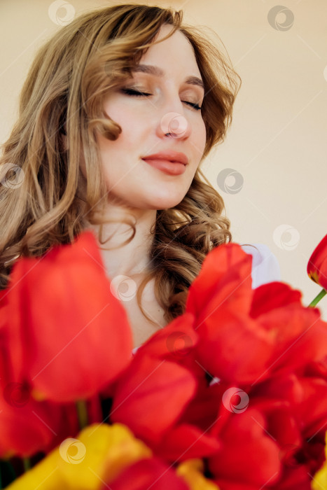 Скачать Молодая женщина держит букет красных тюльпанов. Концепция 8 марта, Дня святого Валентина. Прекрасный подарок для девушки. Весенний портрет женщины. фотосток Ozero