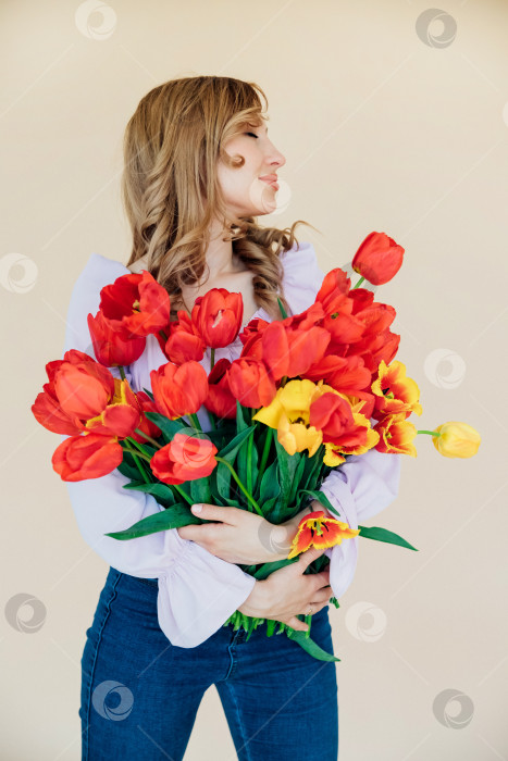 Скачать Молодая женщина держит букет красных тюльпанов. Концепция 8 марта, Дня святого Валентина. Прекрасный подарок для девушки. Весенний портрет женщины. фотосток Ozero