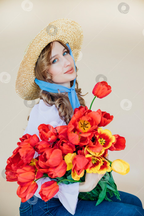 Скачать Молодая женщина держит в руках букет красных тюльпанов. Концепция 8 марта, Дня святого Валентина. Замечательный подарок для девушки. Весенний портрет женщины в соломенной шляпе. фотосток Ozero