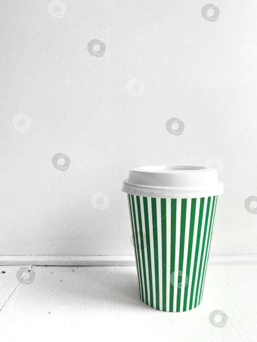 Скачать Кофейная чашка в зеленую полоску, вертикальное фото. Уличная еда, кофе на вынос фотосток Ozero
