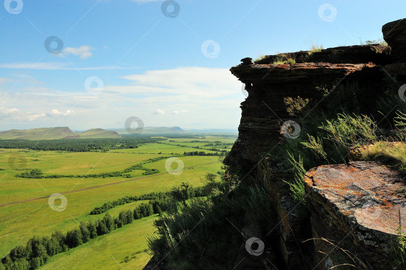 Скачать Плоская вершина холма из красного слоистого песчаника с видом на бескрайнюю летнюю степь. фотосток Ozero