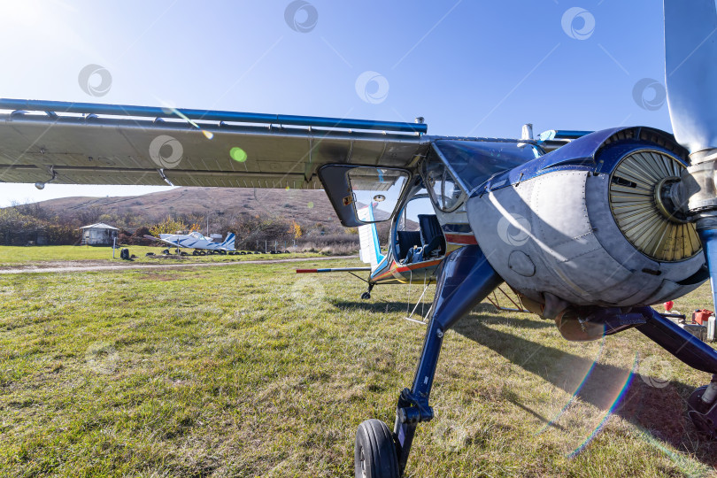 Скачать Небольшой легкомоторный самолет стоит на полевом аэродроме фотосток Ozero