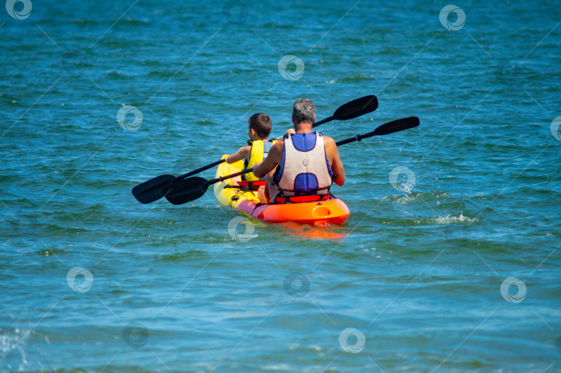 Скачать отец и сын плывут по морю на байдарке фотосток Ozero