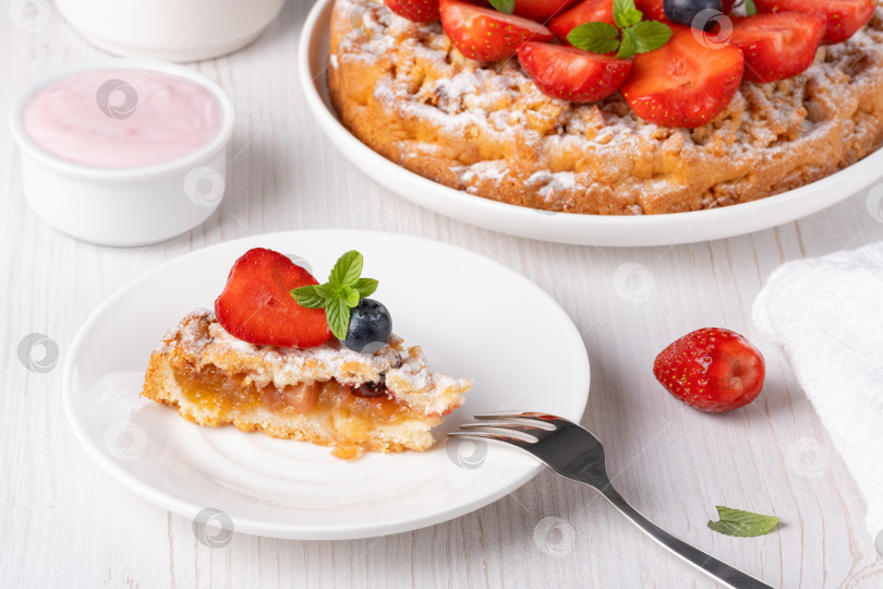 Скачать Сладкий пирог с клубникой на тарелке на белом деревянном фоне фотосток Ozero