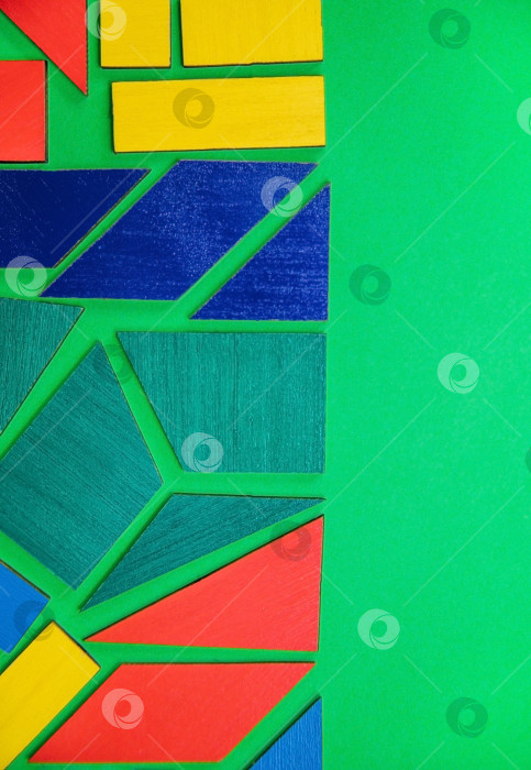 Скачать Абстрактный фон.Геометрические фигуры разных цветов на зеленом фоне. Концепция логического мышления. фотосток Ozero