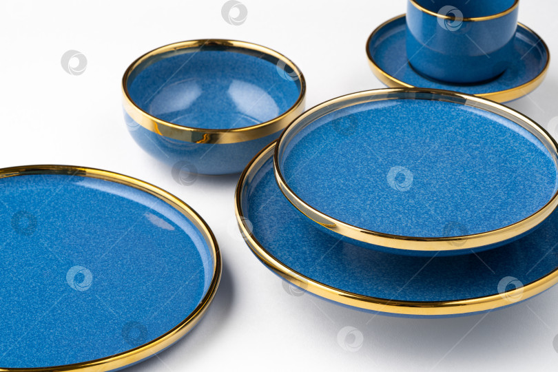 Скачать Набор синих керамических тарелок и чашек на белом фоне фотосток Ozero