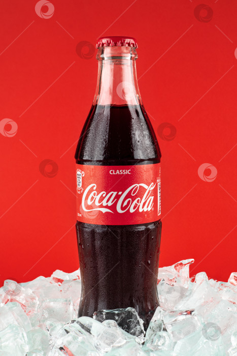 Скачать Батуми, Грузия - 10 июля 2023 года: Стеклянная бутылка Coca-Cola на льду. Coca-Cola - самый популярный газированный напиток в мире. фотосток Ozero