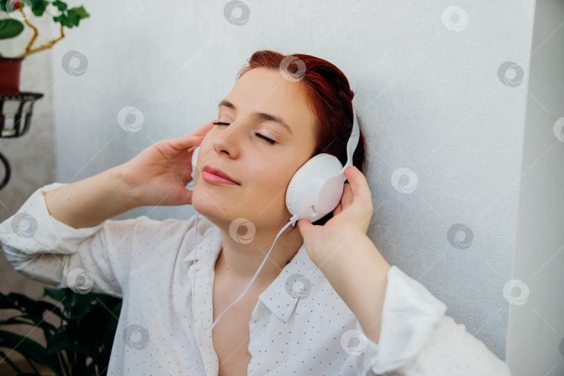 Скачать Красивая молодая женщина слушает музыку в наушниках. Концепция образа жизни людей. Наслаждаясь мелодией, закрыл глаза. фотосток Ozero
