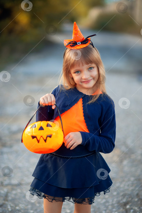 Скачать Девушка в карнавальном костюме на Хэллоуин держит в руках конфету в виде тыквы фотосток Ozero