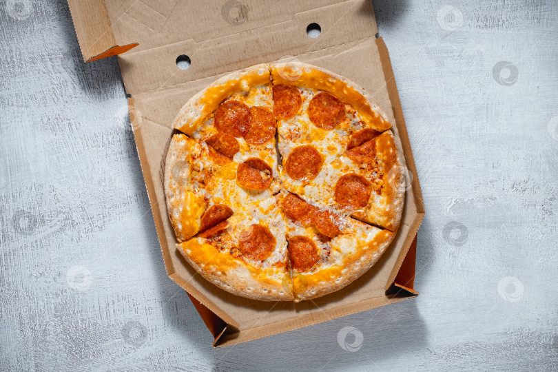 Скачать Пицца пепперони в коробке на светлом фоне фотосток Ozero