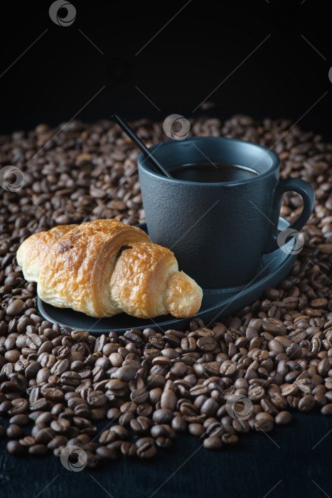 Скачать Чашка свежего кофе с круассаном на темном фоне фотосток Ozero