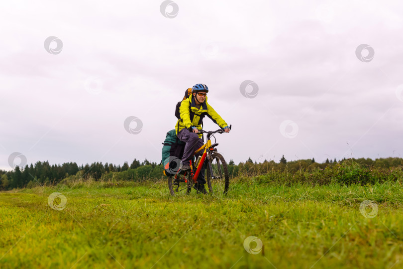 Скачать турист на велосипеде едет по грунтовой дороге через поле фотосток Ozero