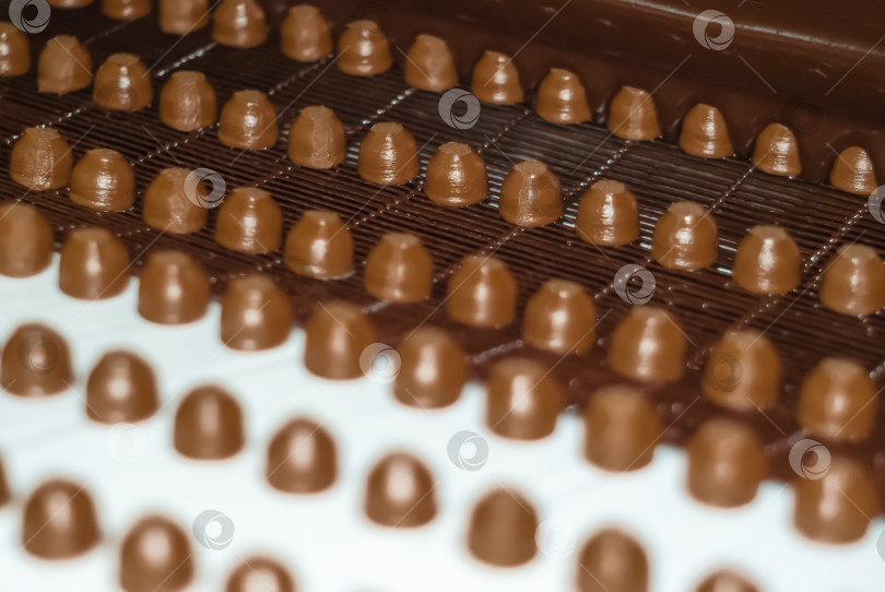 Скачать шоколадные начинки в процессе заливки жидкого шоколада на фотосток Ozero