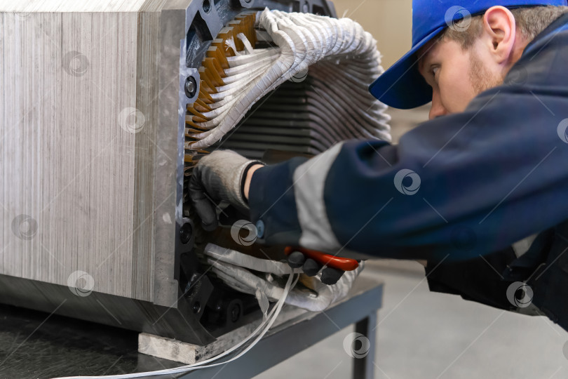 Скачать рабочий, ремонтирующий обмотку статора электродвигателя на производстве фотосток Ozero