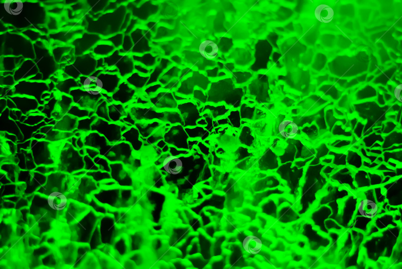 Скачать размытый абстрактный фон - потрескавшийся лед, подсвеченный зеленым светом. фотосток Ozero