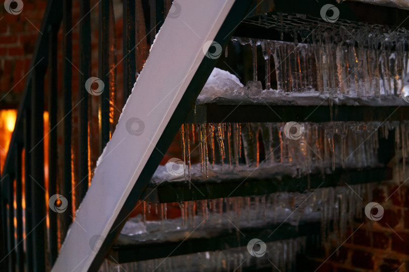 Скачать зимний фон - сосульки на наружной лестнице, освещенные фонарем фотосток Ozero