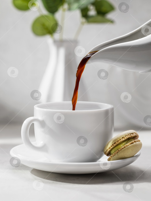 Скачать Натюрморт с процессом наливания кофе в белую керамическую чашку фотосток Ozero