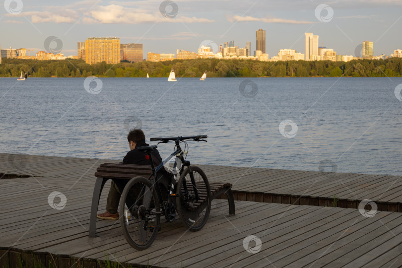 Скачать Мужчина отдыхает на берегу Строгинского залива. Москва фотосток Ozero