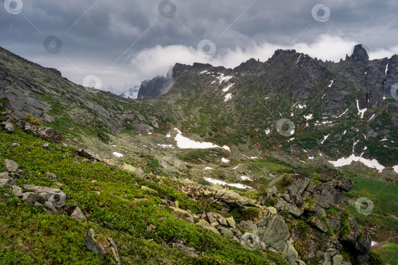 Скачать Зеленое высокогорное плато на фоне дождливого и туманного фотосток Ozero